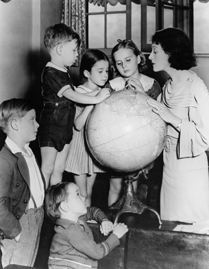 Woman and children looking at globe