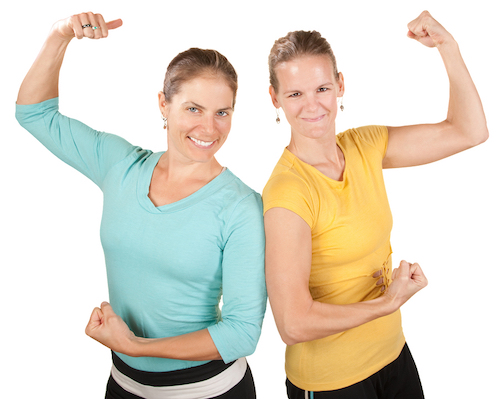 Two smiling women show off their biceps