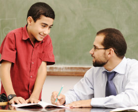 boy at tchr desk 280