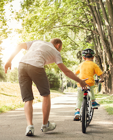 man-helping-son-ride-bike