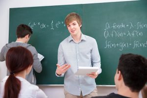 High school students discussing homework in front of the blackboard