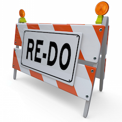 A construction barricade sign with word Re-Do to illustrate a need to revise, change or improve to a