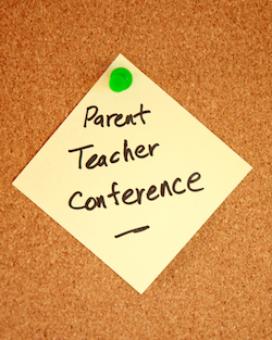 "PARENT TEACHER CONFERENCE" written on a sticky note and tacked to a corkboard.