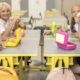 Group of four smiling students in a bright cafeteria enjoying lunch at yellow tables with lunchboxes and bottles nearby.